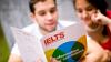 Students reading an IELTS brochure