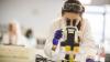 Image of a woman looking into a microscope